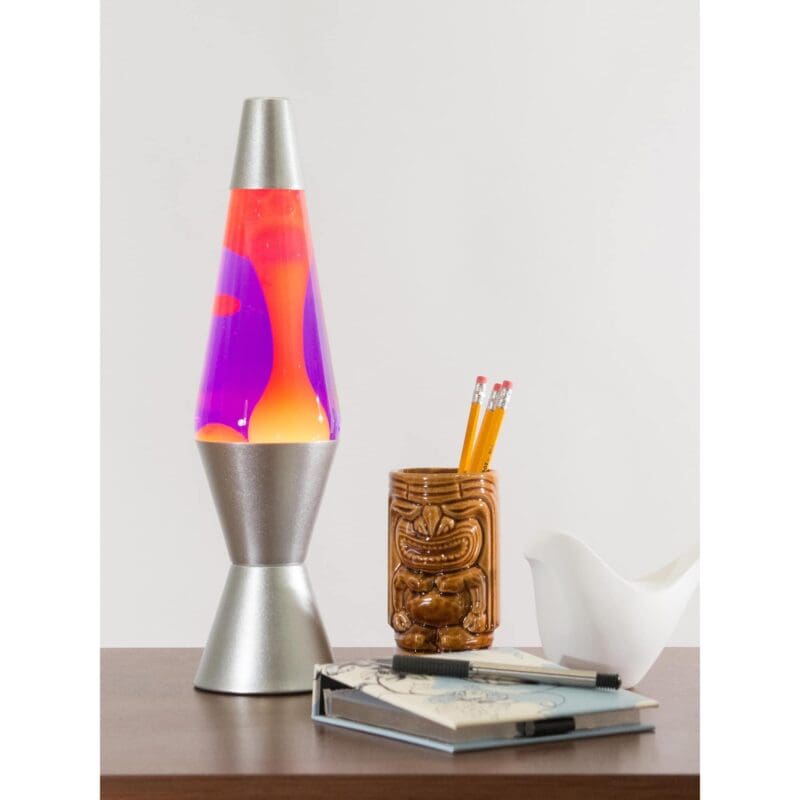 21250401US-LavaLamp-14-5-Yellow-and-Purple-web 14.5” LAVA® Lamp – Yellow/Purple/Silver on a table with a notebook and tiki mug pencil cup